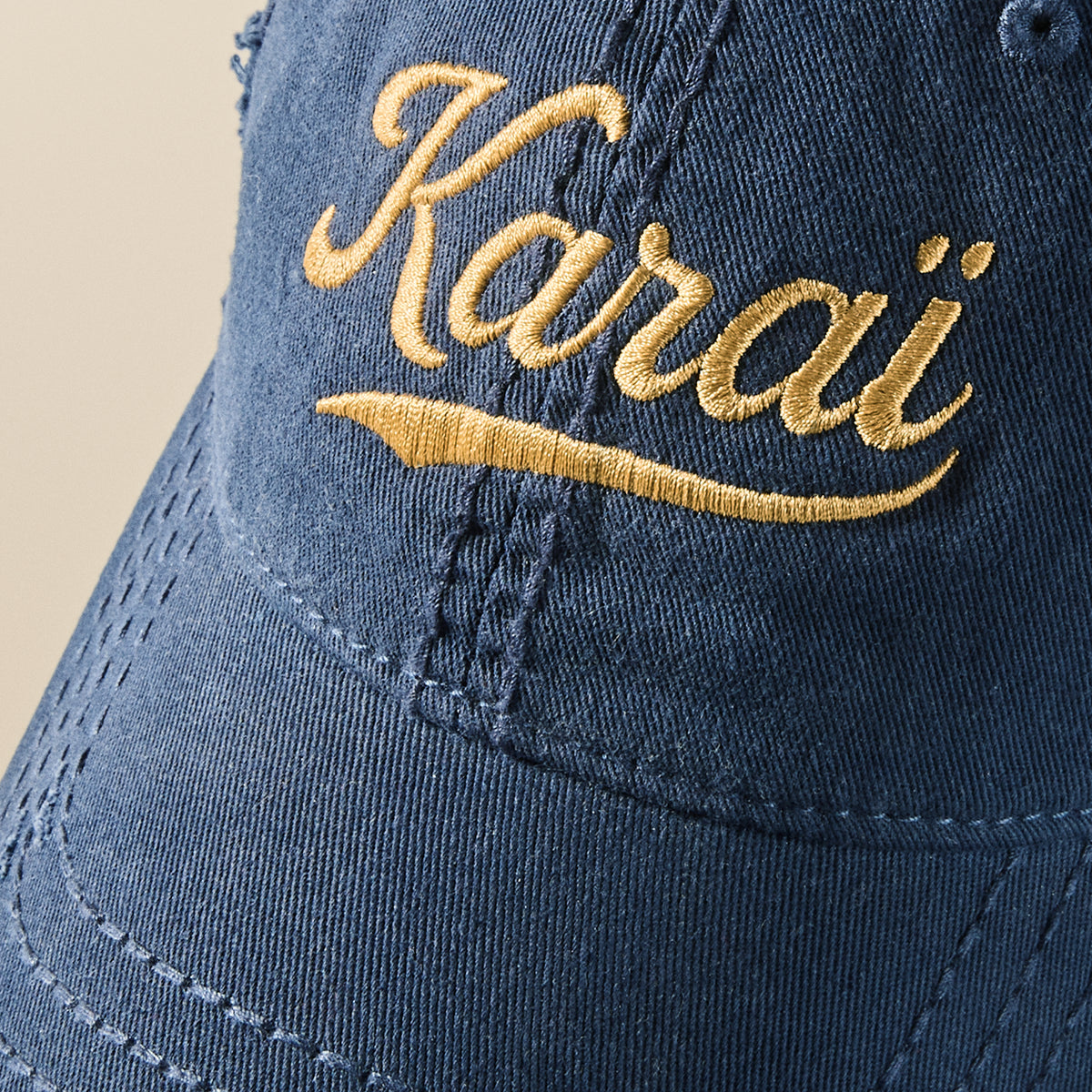 Gros plan serré de la broderie Karaï fil doré sur le coton marine délavé de la casquette effet usé, TifoArt