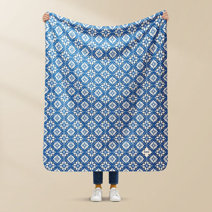 Plaid Azulejo 02 Portugal en sherpa, tenu à la main, motif carreaux bleus