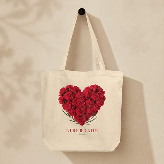 Sac tote crème oyster suspendu sur mur, cœur d'œillets rouges et texte Liberdade, série Œillets 25 avril Portugal TifoArt