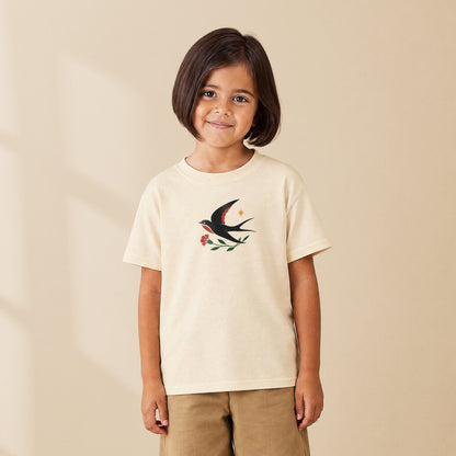 T-shirt enfant crème Hirondelle folk porté par une enfant, série Folklore Portugais TifoArt
