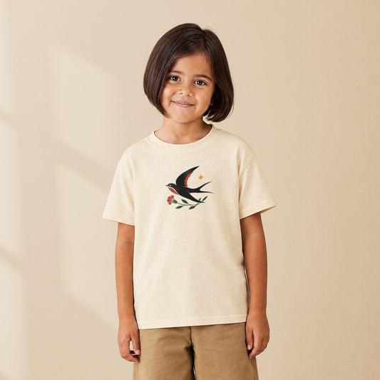 T-shirt enfant crème Hirondelle folk porté par une enfant, série Folklore Portugais TifoArt