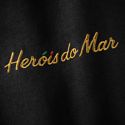 Gros plan serré de la broderie Heróis do Mar, fil doré sur coton Comfort Colors noir, t-shirt TifoArt