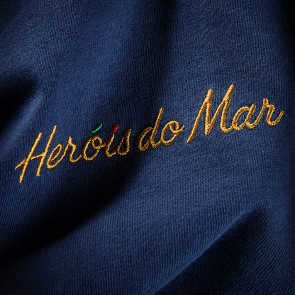 Gros plan de la broderie Heróis do Mar fil doré côté cœur sur coton Comfort Colors marine, t-shirt TifoArt