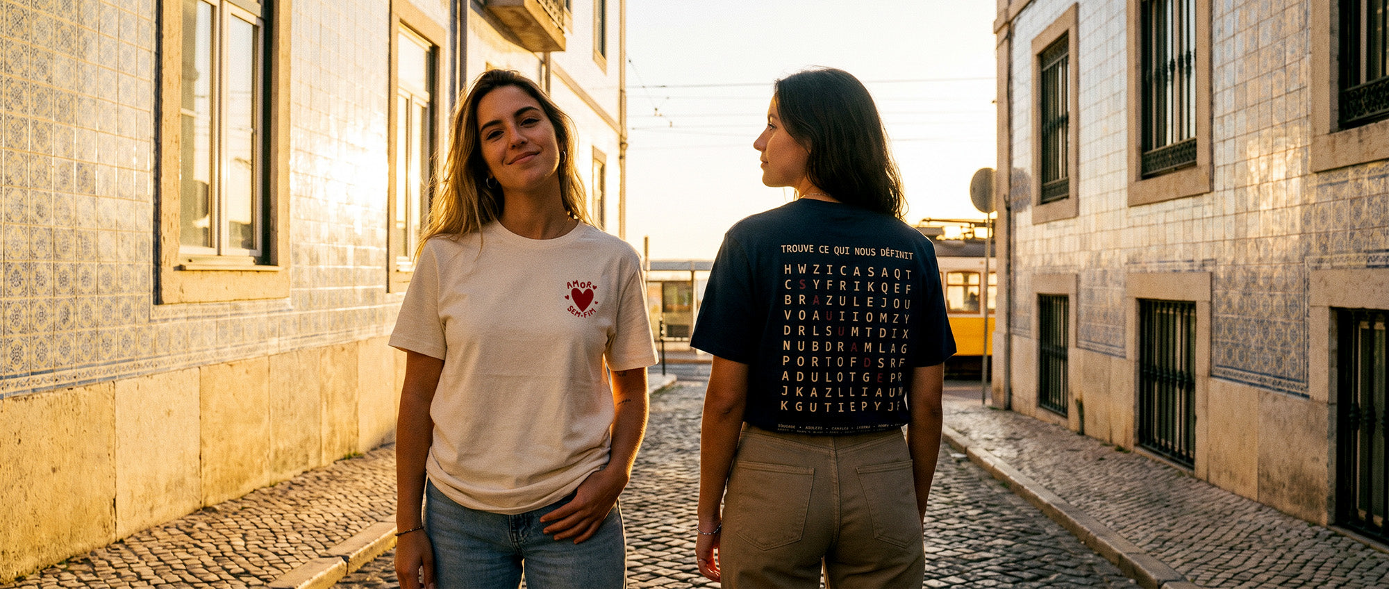 Deux femmes à Lisbonne portant les t-shirts portugais TifoArt Amor Sem Fim et Saudade au coucher du soleil